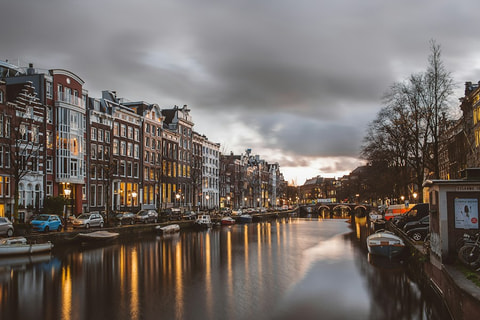 Historic canal houses reflected in the water in Amsterdam